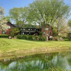The Old Orchard Home surrounded by a small apple orchard, large meadows, and a private pond