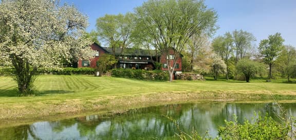 The Old Orchard Home surrounded by a small apple orchard, large meadows, and a private pond